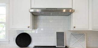 Range Hood Charcoal Filters: How Often to Replace Them & What to Buy Range hood charcoal filters and metal grease filter on a kitchen counter below a ductless hood