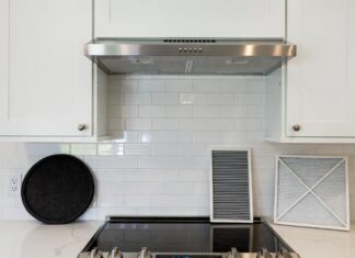 Range Hood Charcoal Filters: How Often to Replace Them & What to Buy Range hood charcoal filters and metal grease filter on a kitchen counter below a ductless hood